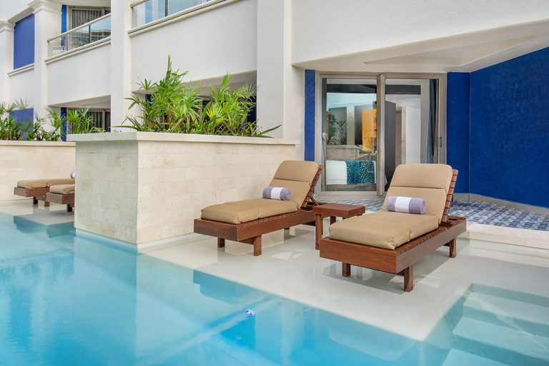 Swim up pool patio with lounge chairs attached to a guest suite.