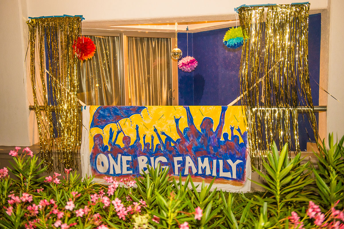 A decorated room balcony with a painted sign that says "One Big Family".