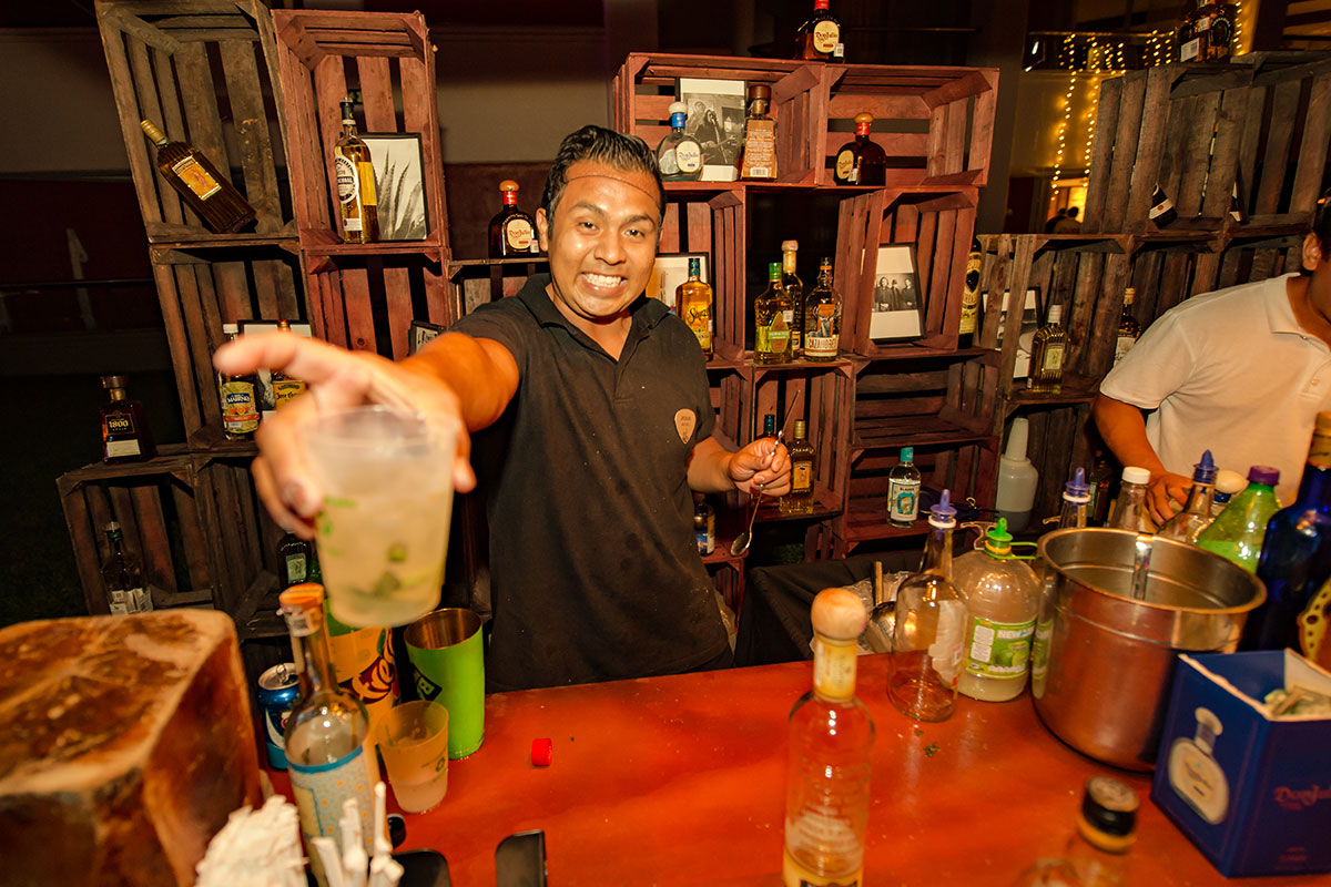 A bartender handing a guest a drink.