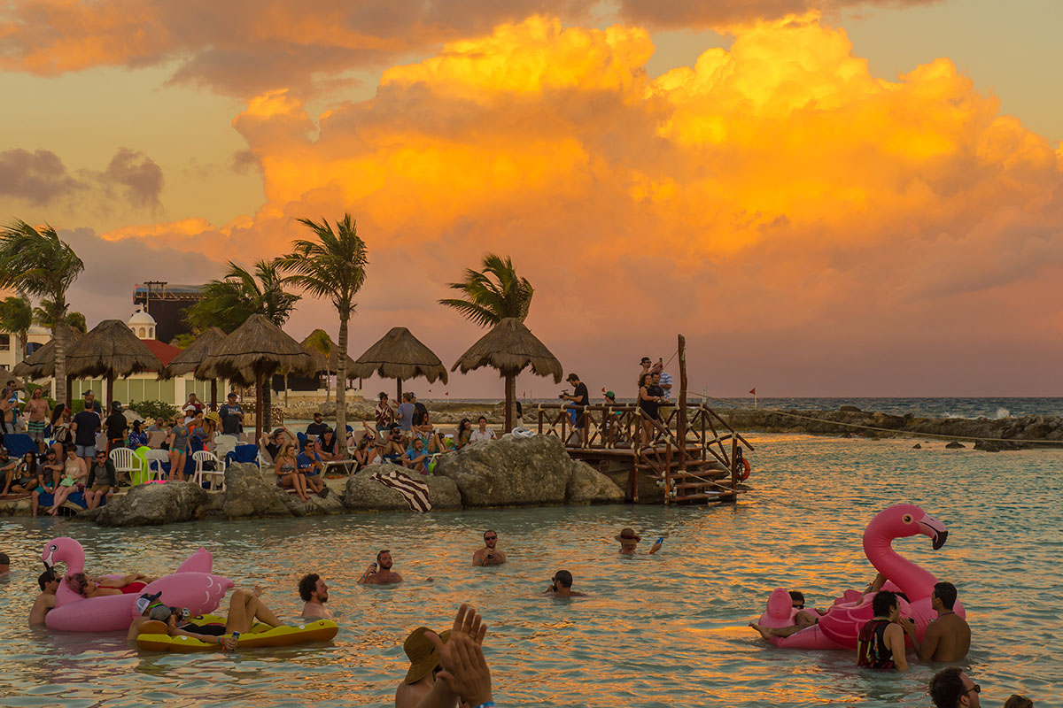 A lagoon with guests swimming during sunset.