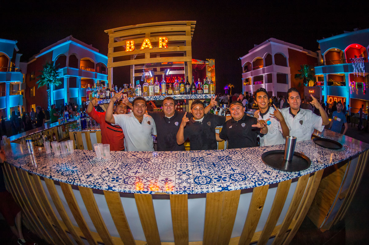 A group photo of resort bartenders with their hands up.
