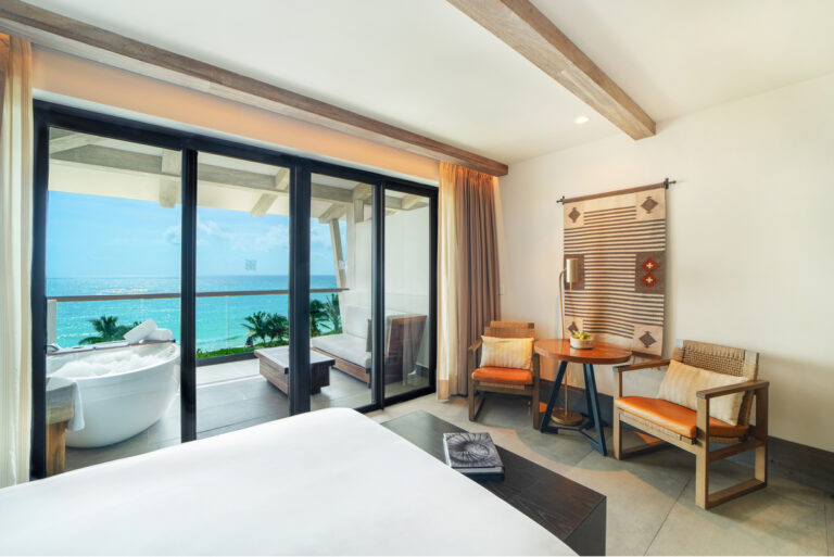 Alcoba Suite bedroom area with an ocean view balcony in the background.