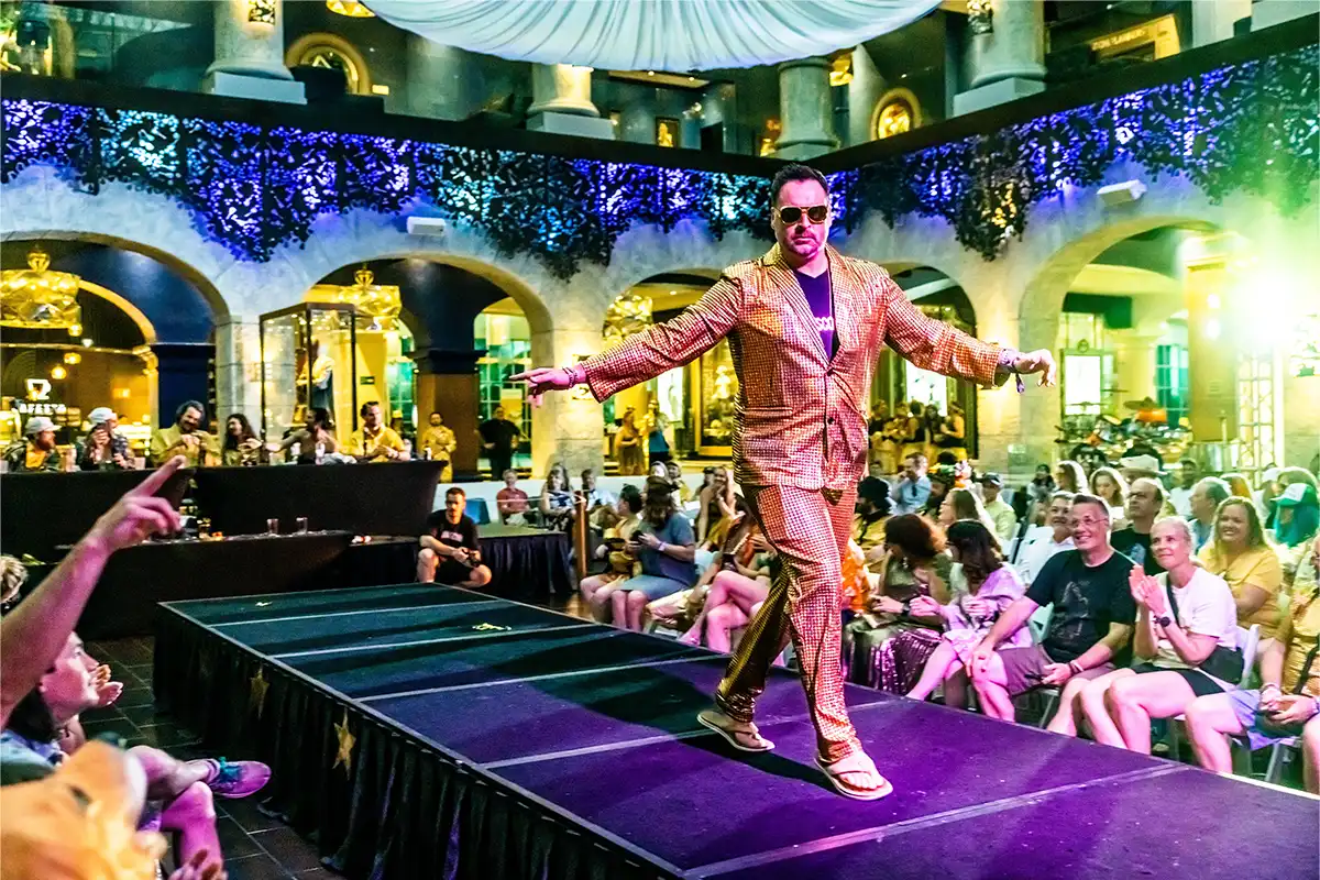 A guest posing on a stage during a costume contest.