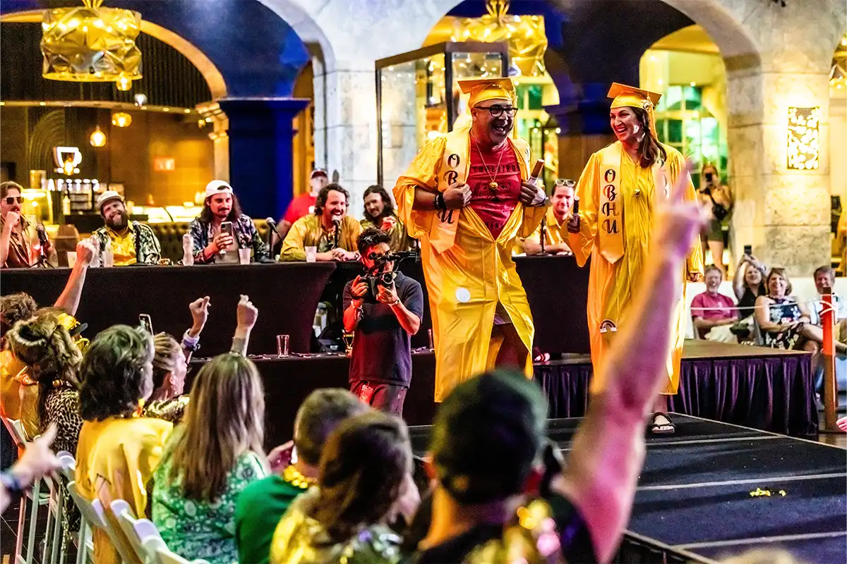 Guests on a stage in theme night costumes during a costume contest.
