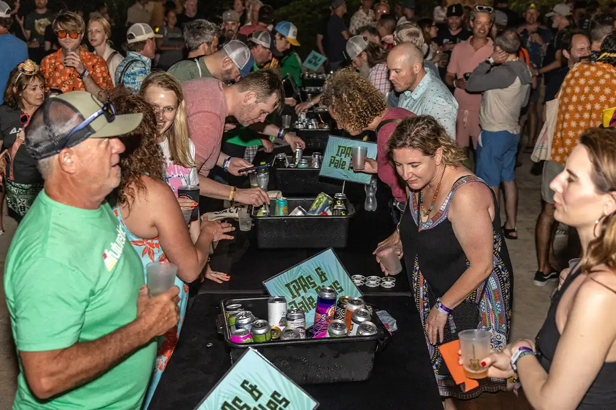 Guests participating in a Beer Share activity, various drinks presented on a table.