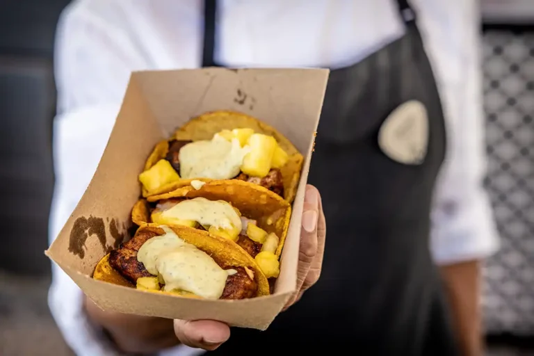 A tray of Tacos being held towards the camera.