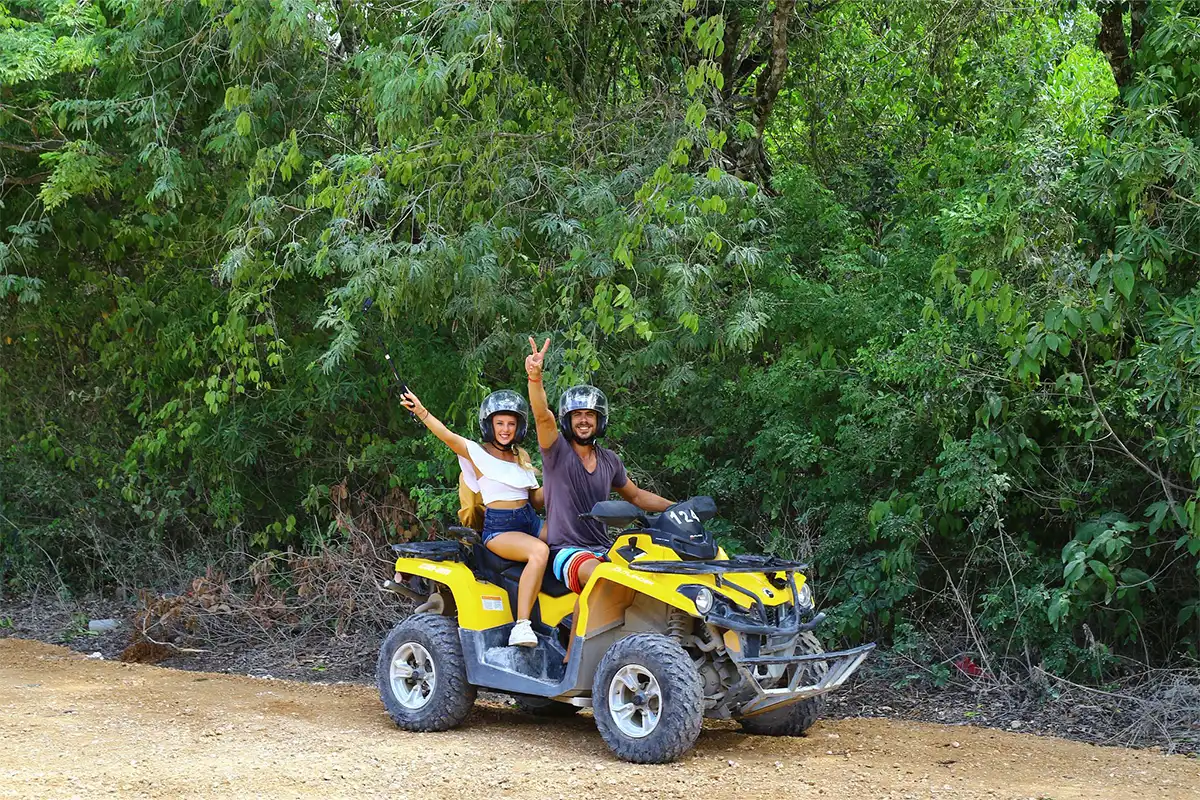 Guests with their hands up on an ATV.
